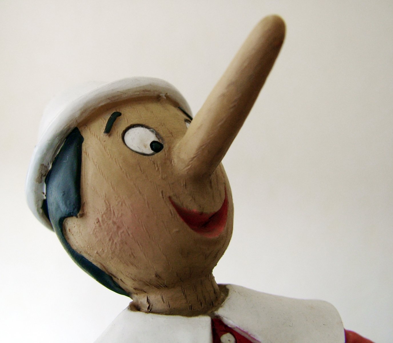 a wooden figurine that is pointing with its hand