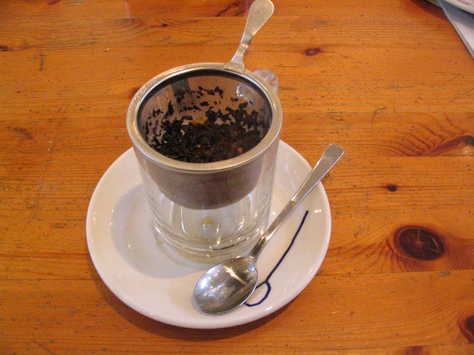 there is a cup of coffee with a spoon next to it