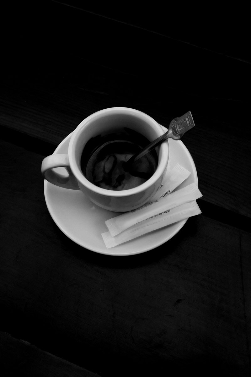 a cup of black coffee on top of a saucer
