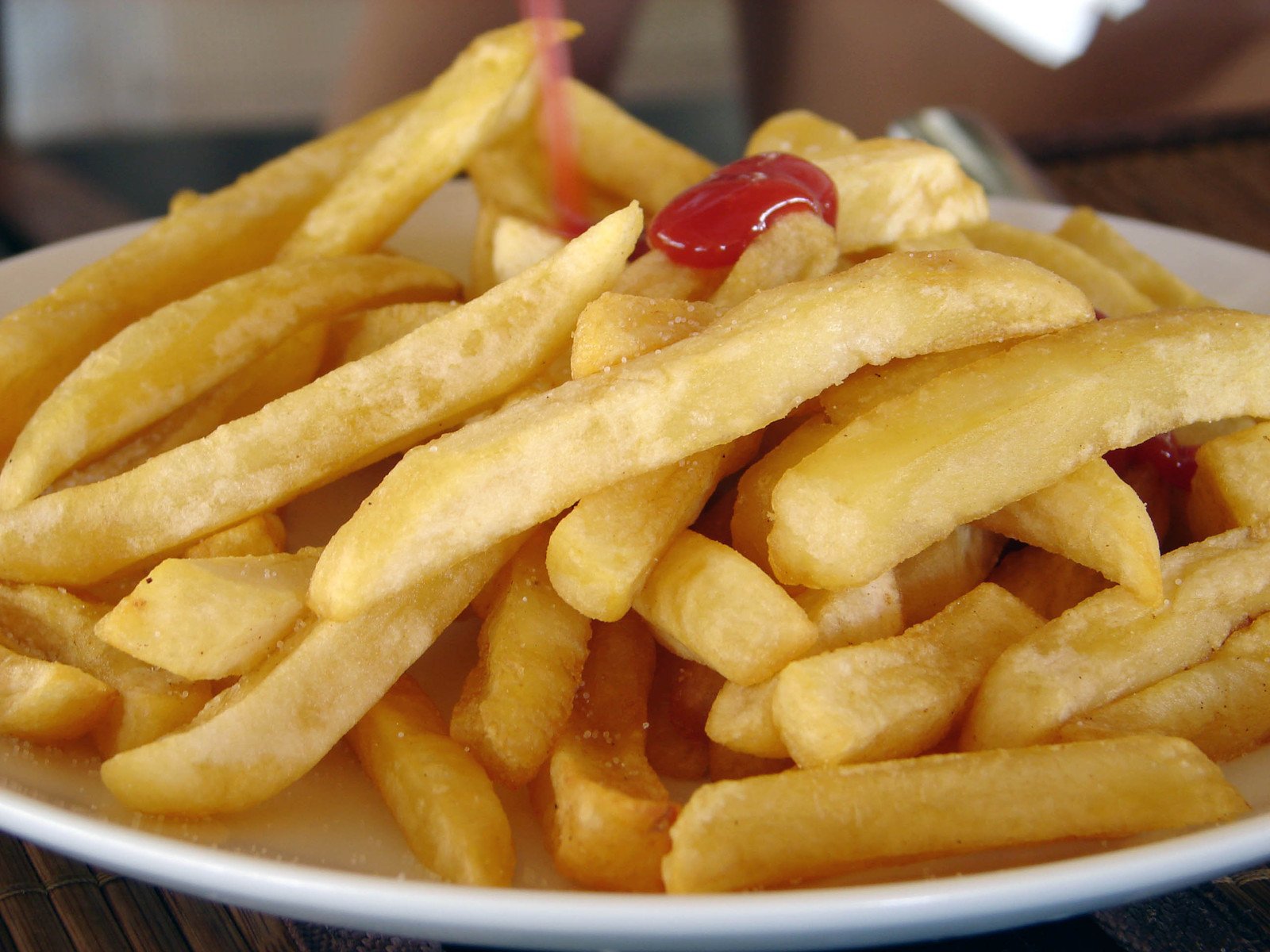 a close - up of french fries with ketchup and a cherry