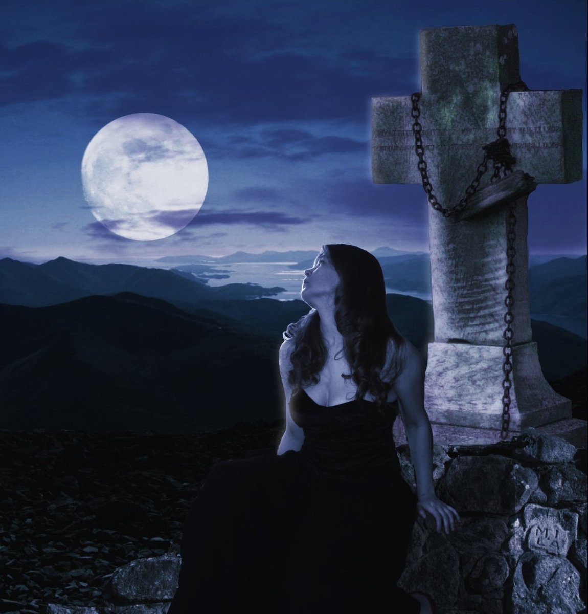 a lady in evening dress sits at a stone cross and looks into the sky