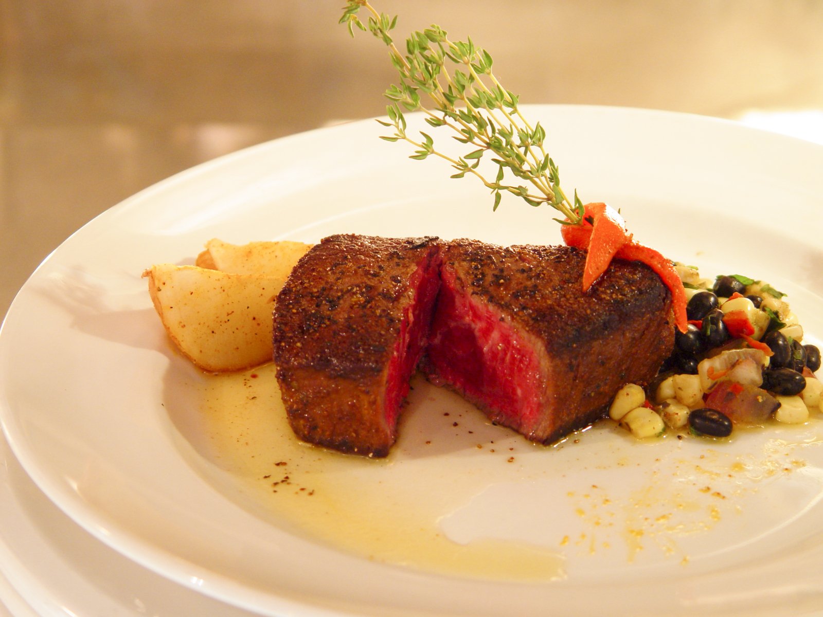 beef and vegetable dish served with small corn couscous on plate