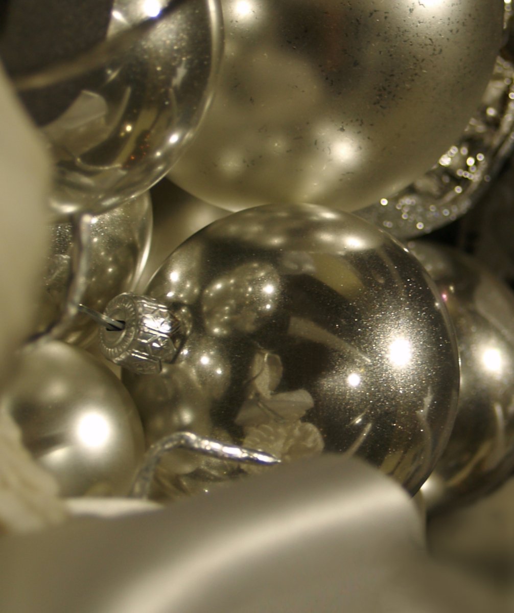 a close up picture of silver ornaments on top of a metal bowl