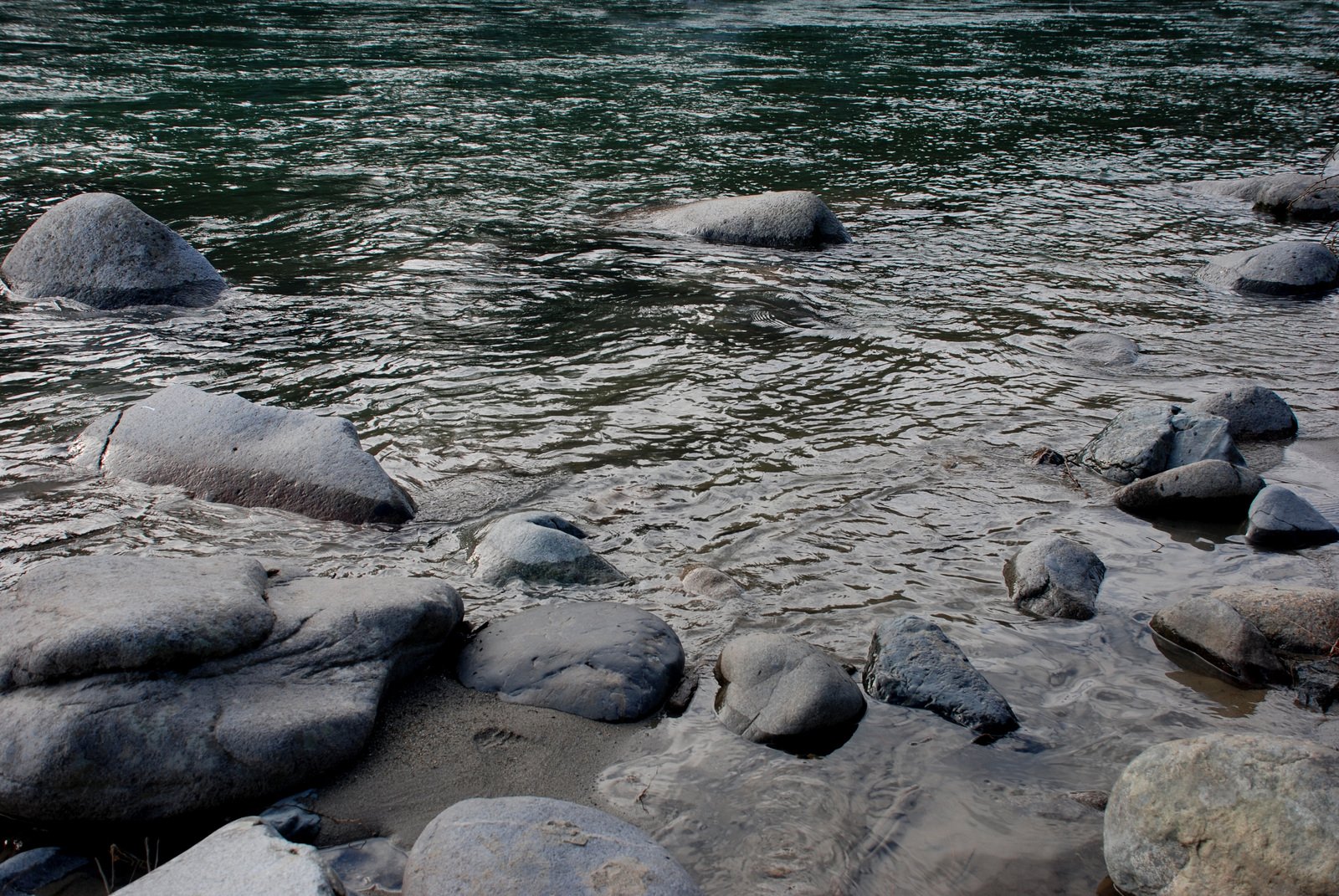 rocks in the water with a large body of water