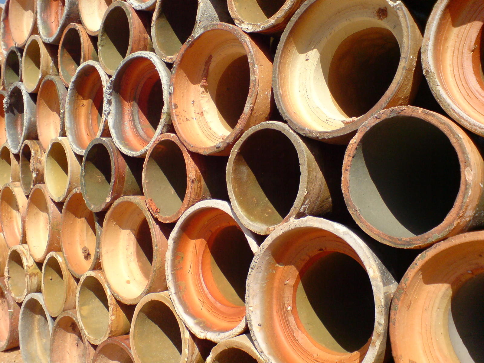 stacks of clay barrels are displayed stacked up