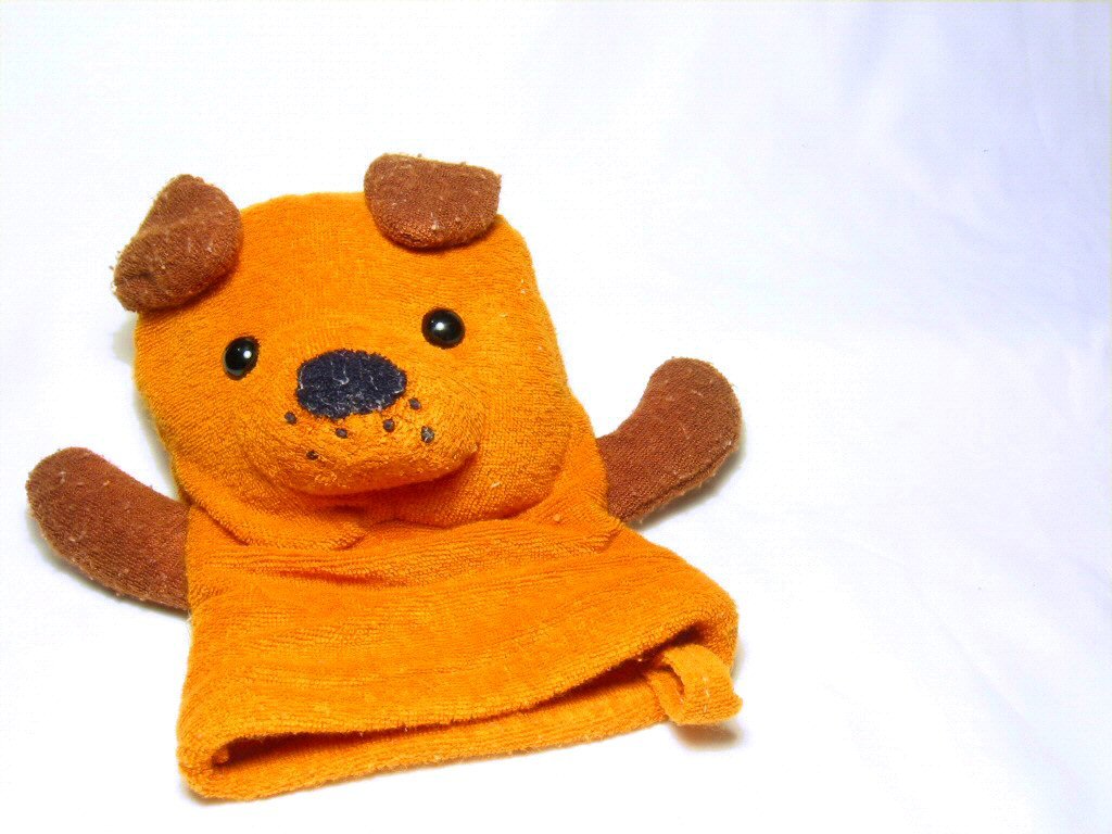 the teddy bear is lying in a towel on the floor