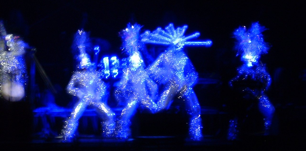 some glowing performers on stage during a show