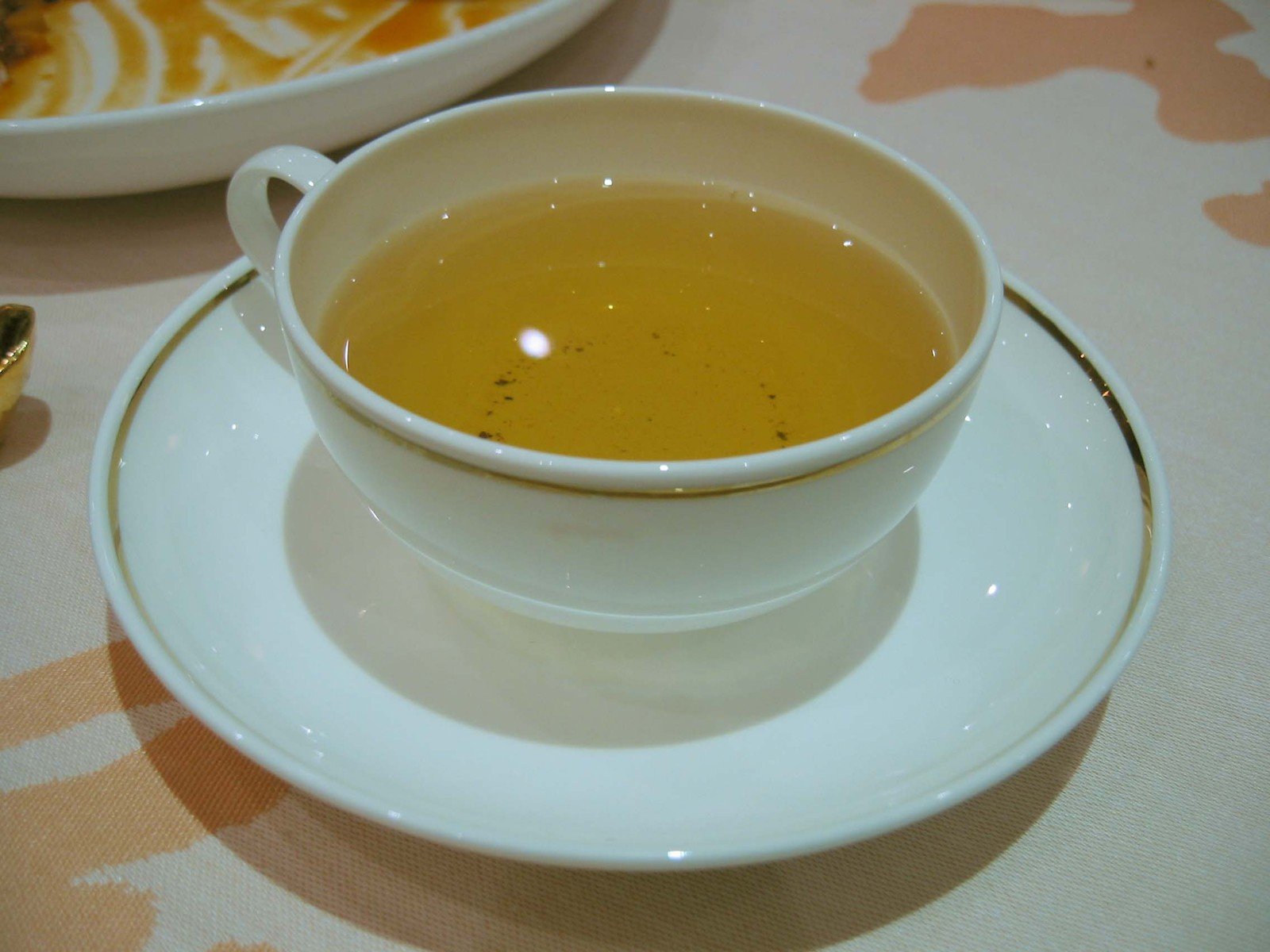 a white plate topped with a bowl filled with liquid