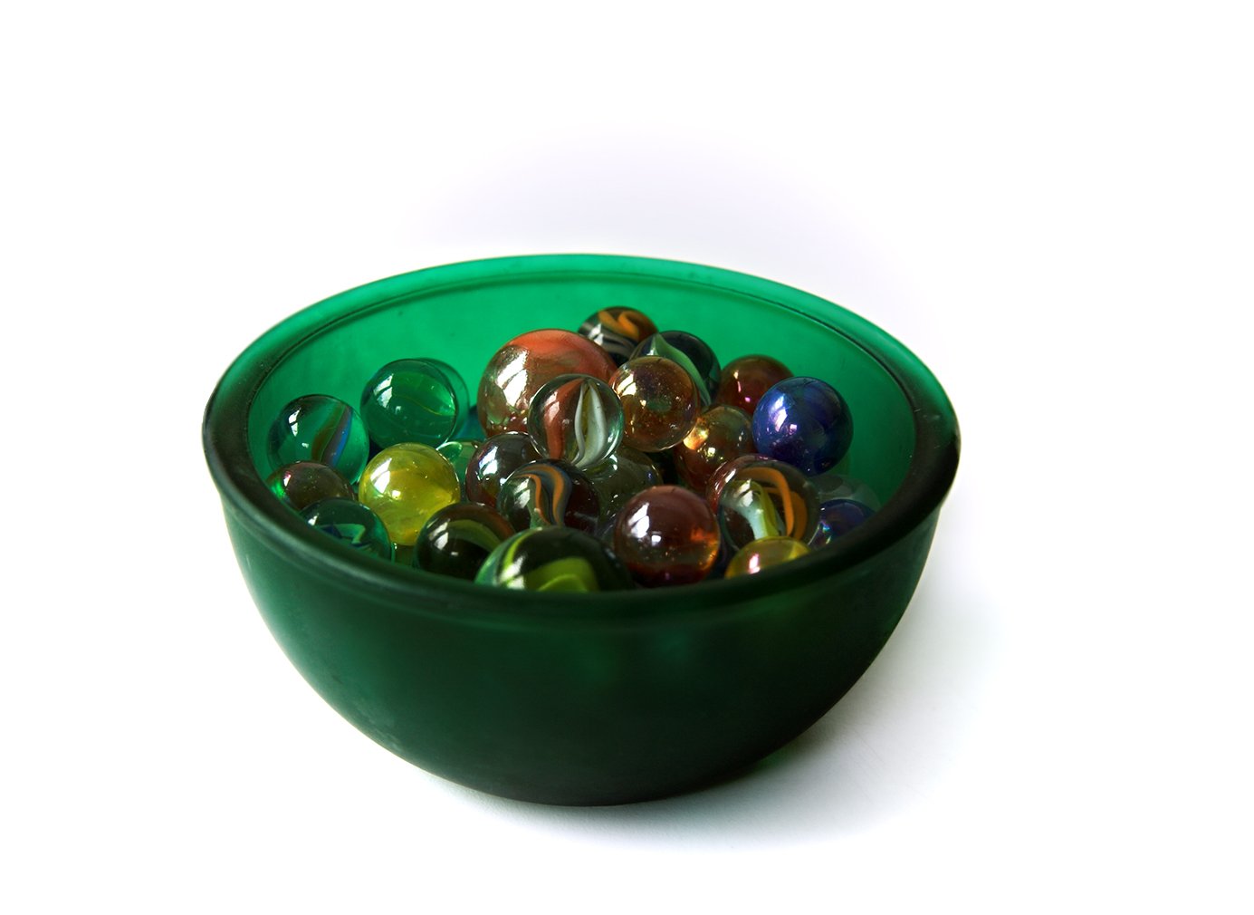 a green bowl that has colored balls in it