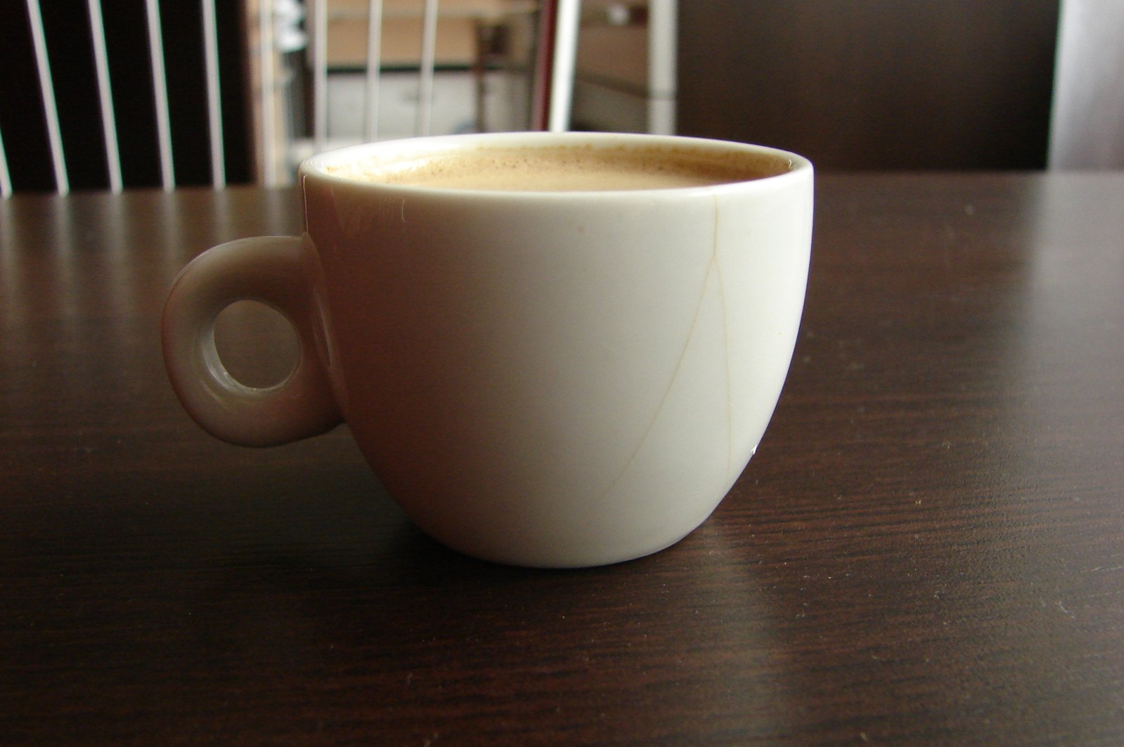 a cup of coffee sitting on top of a wooden table