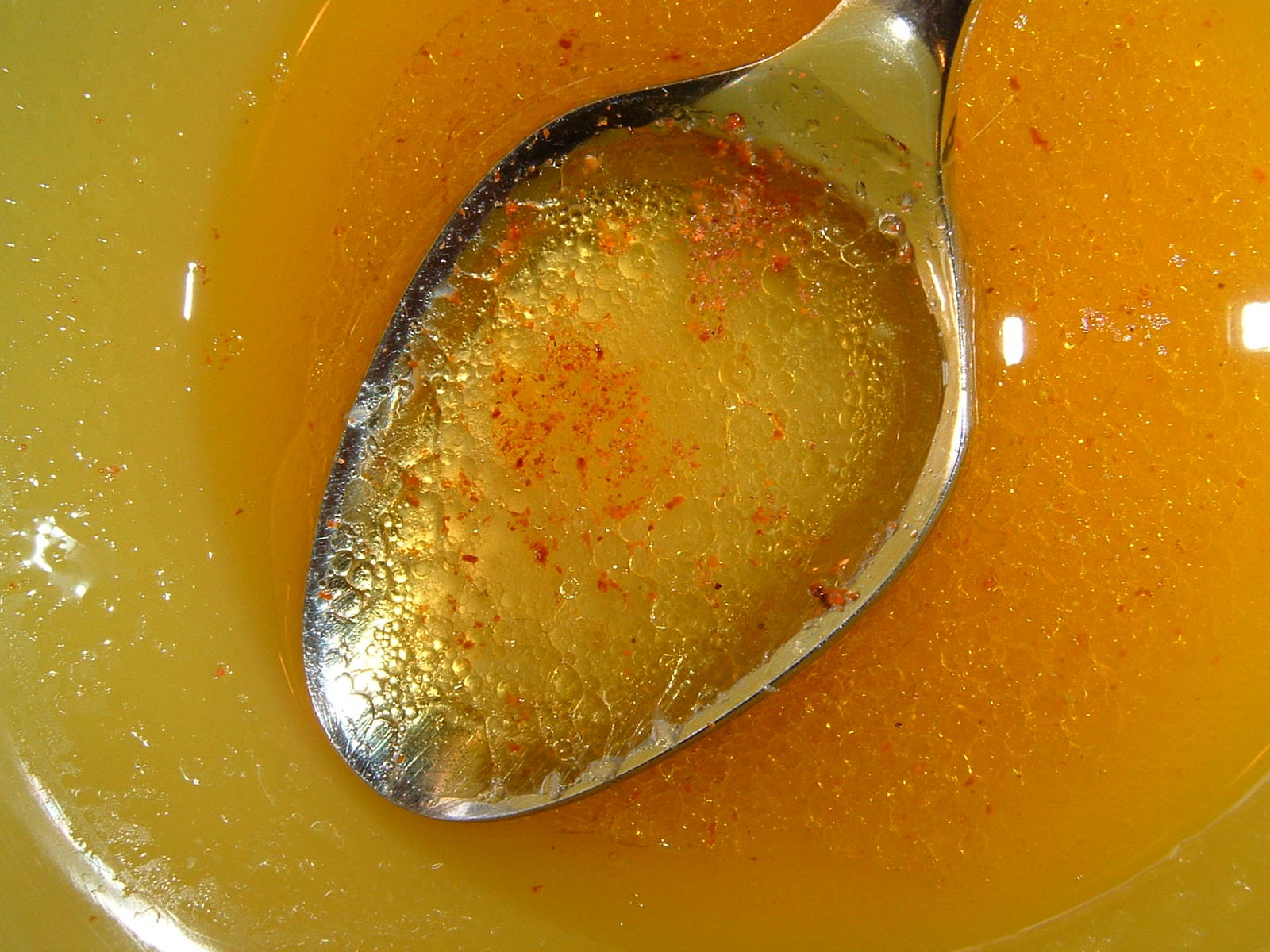 a spoon with food in it sitting on a yellow plate