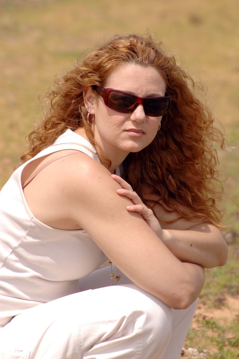 a woman is sitting on the ground posing