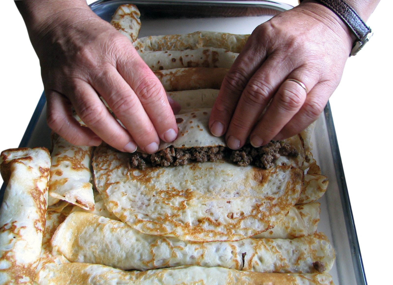 a close up of a person cooking tacos on top of a pan