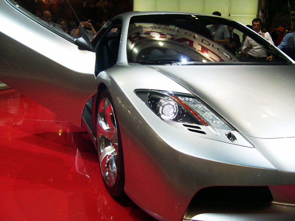 a silver sports car sitting on top of a red floor
