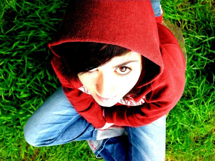 a woman with long black hair wearing a red hooded jacket over her head