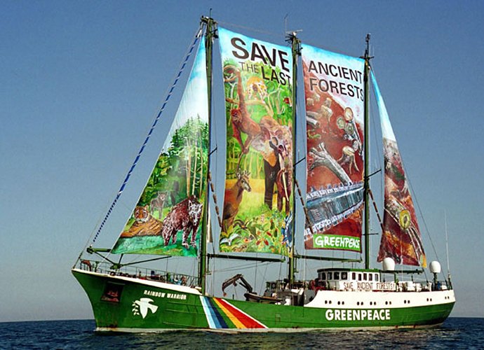 an unusual green boat with large, colorful banners