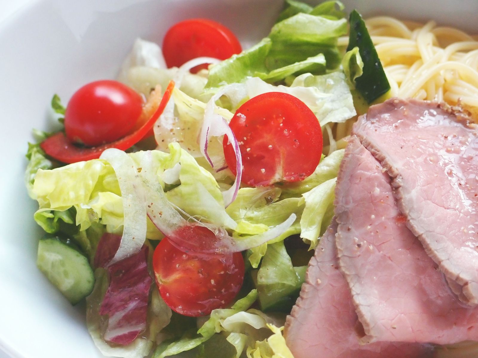 a salad topped with ham and lettuce