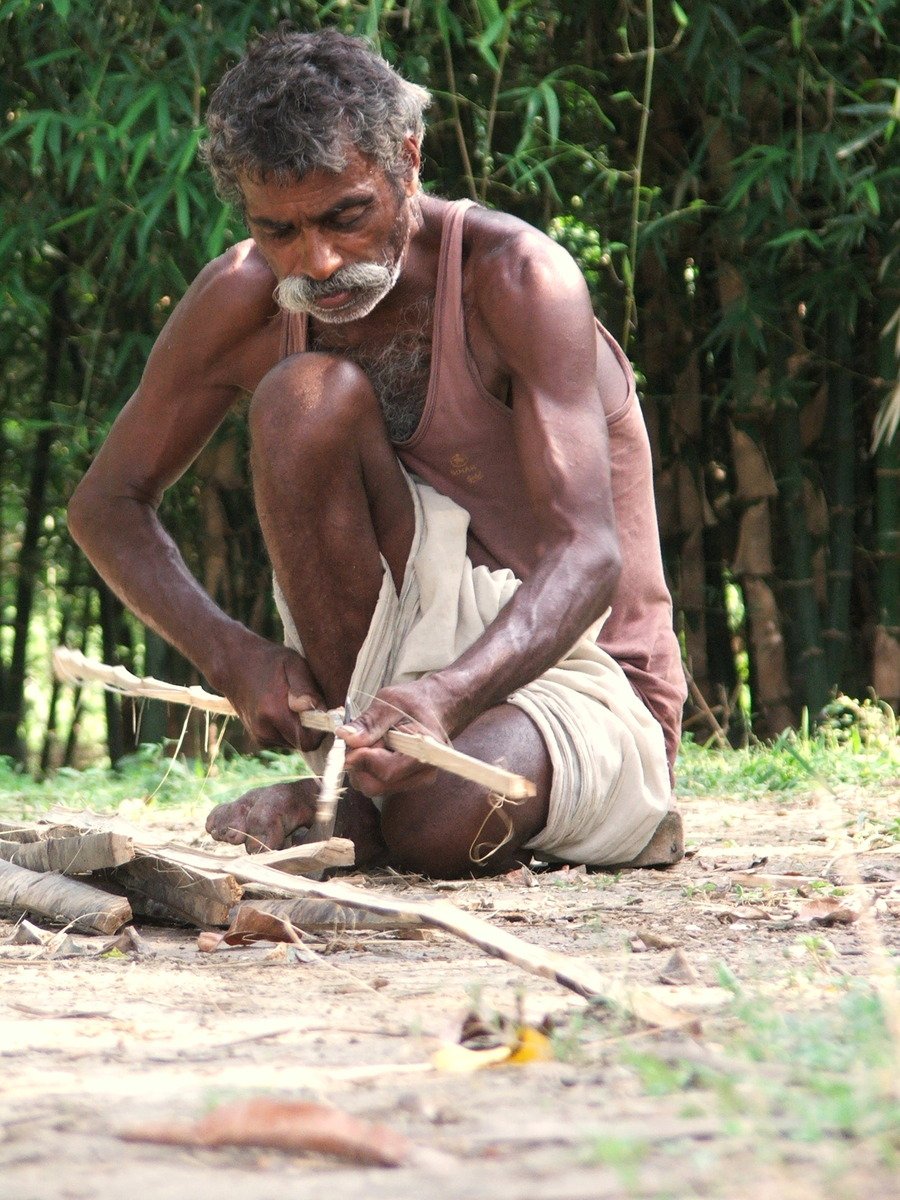 a person that is sitting down holding a stick