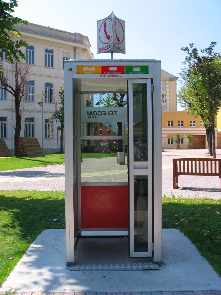 a public phone booth sitting on the grass