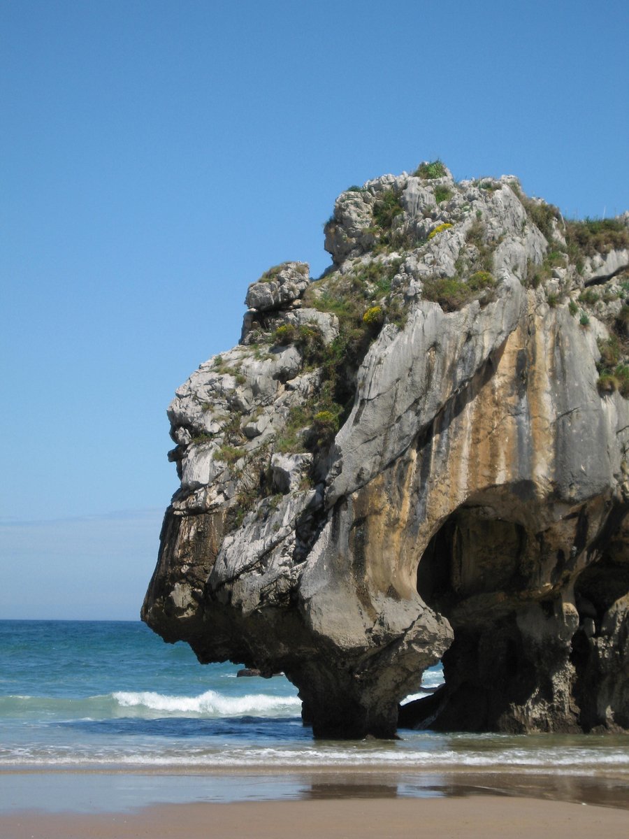 the rocks are sticking out of the ocean near the beach