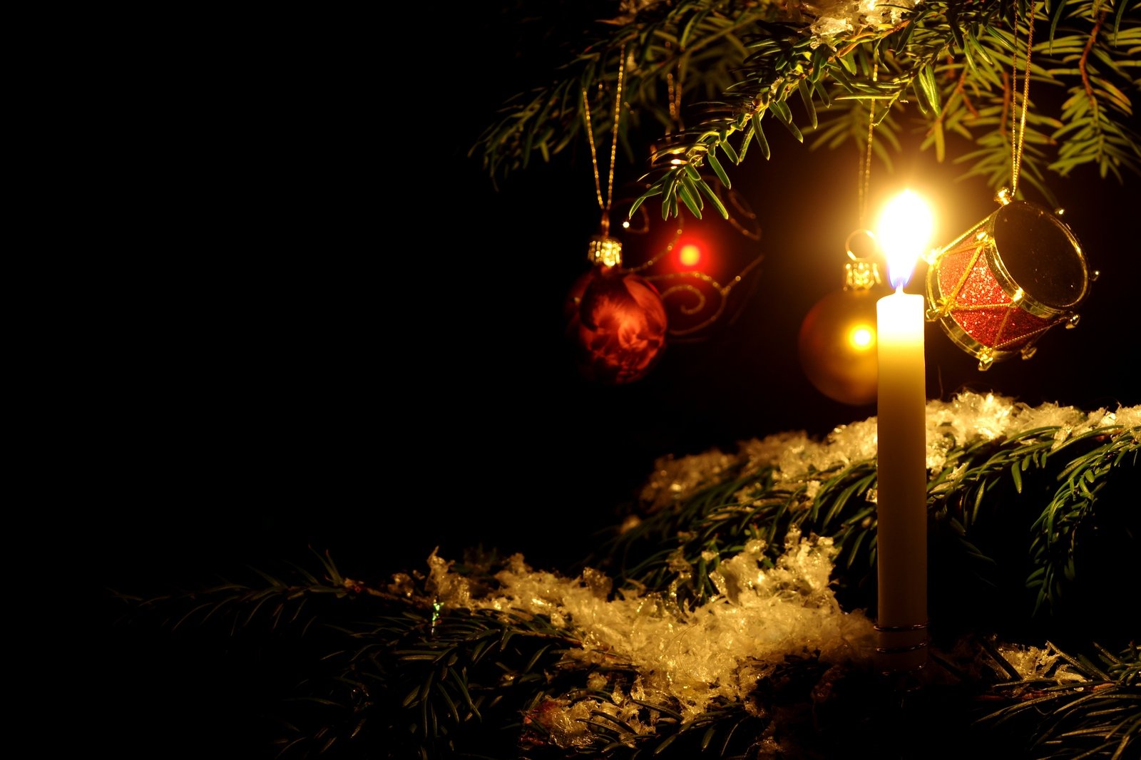 a candle in the middle of some snow covered nches