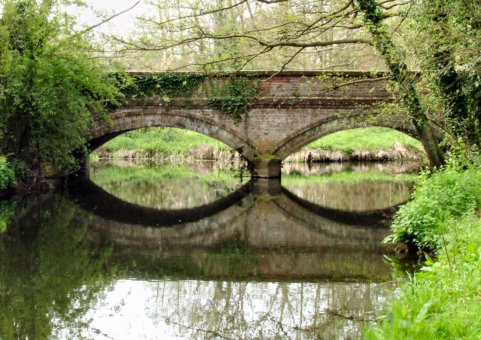 a stone bridge spanning the width of a river