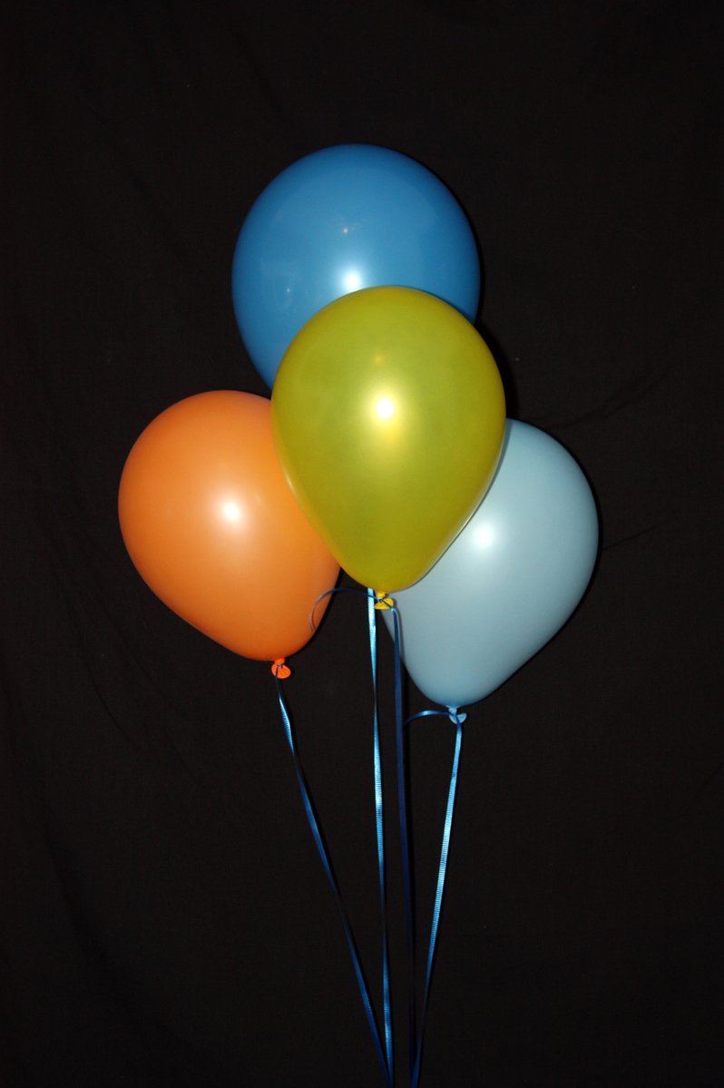 five balloons are placed in a cup with sticks
