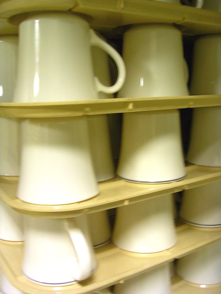 a wooden shelf holding several different kinds of coffee mugs