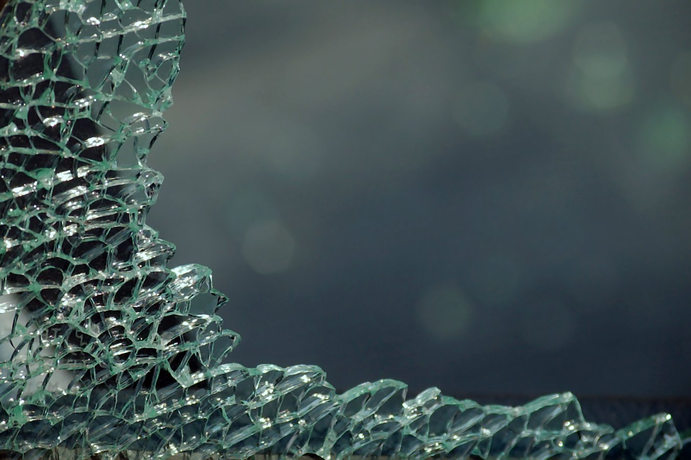 a shattered glass wall against a grey background