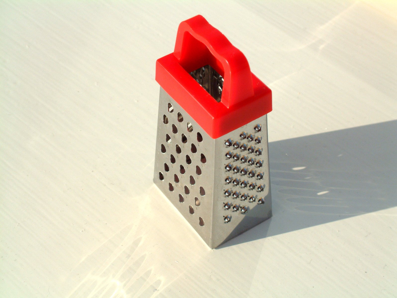 the grater is sitting on a white table