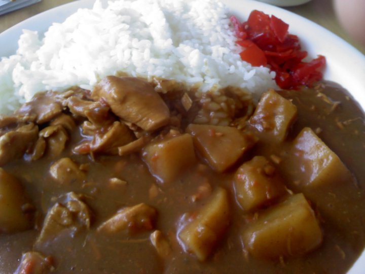 this is a white plate with meat, rice and peppers