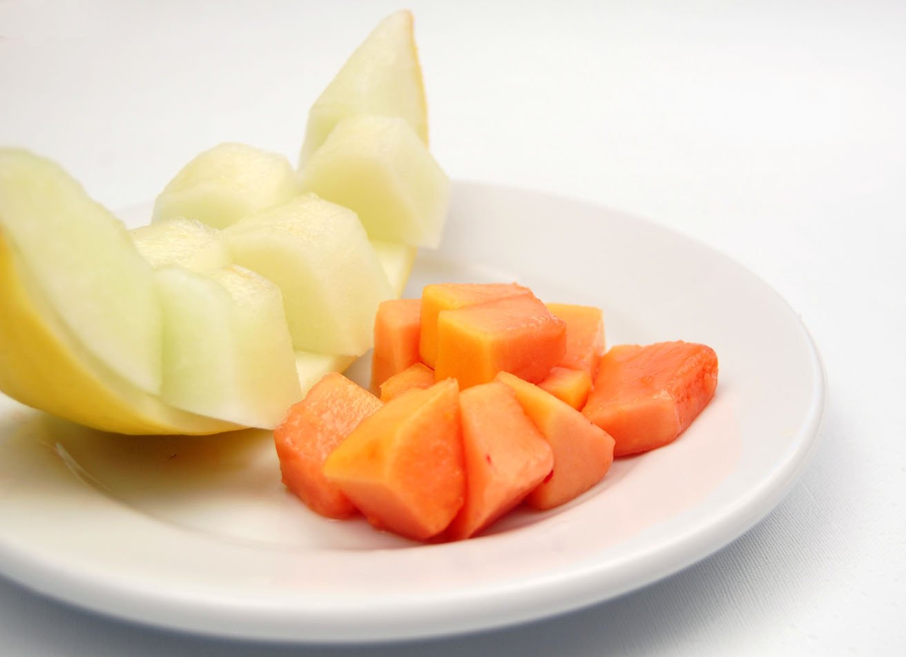 pieces of fruit sit on a plate next to apple slices