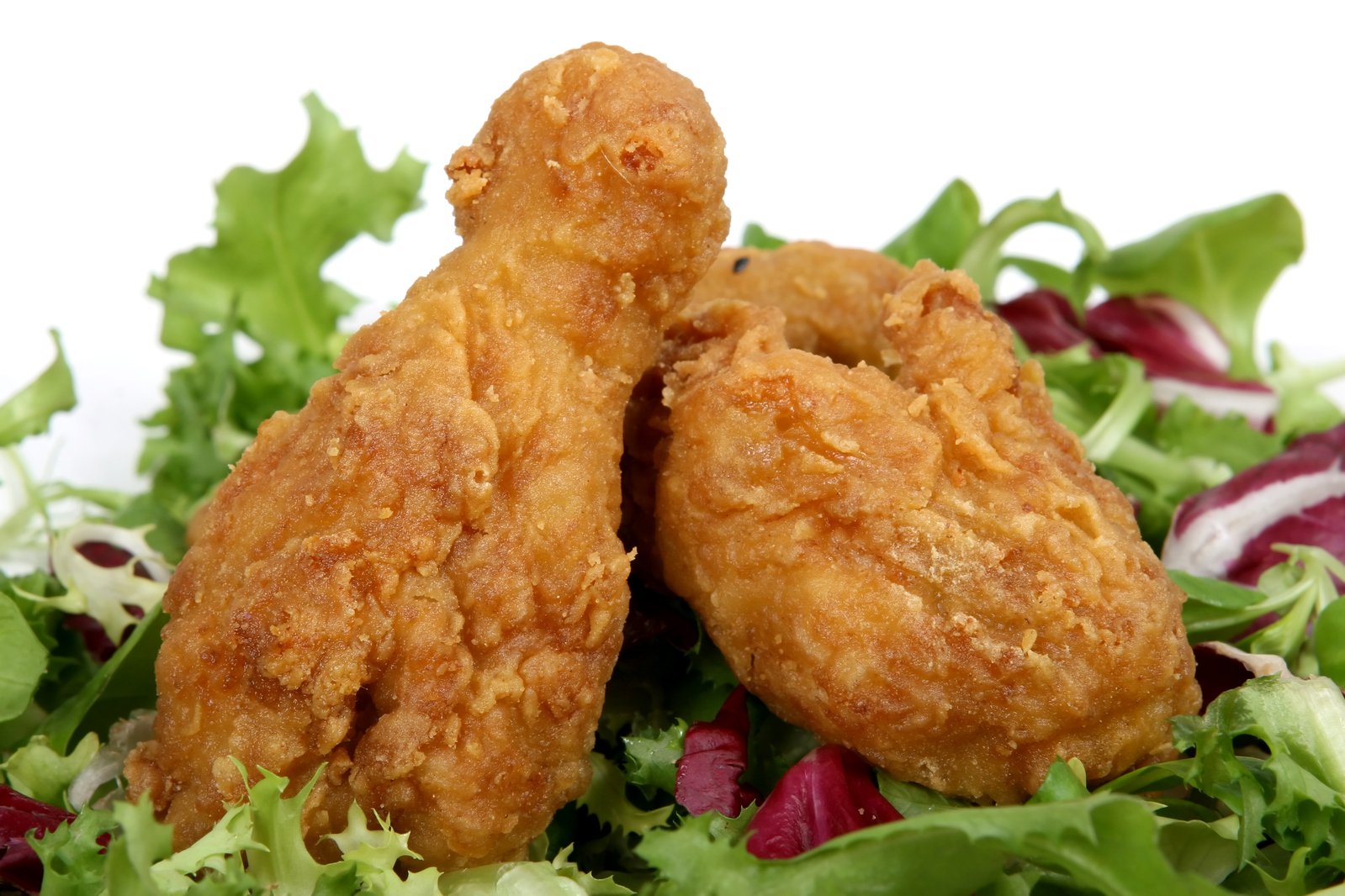 two fried chicken on top of a green salad