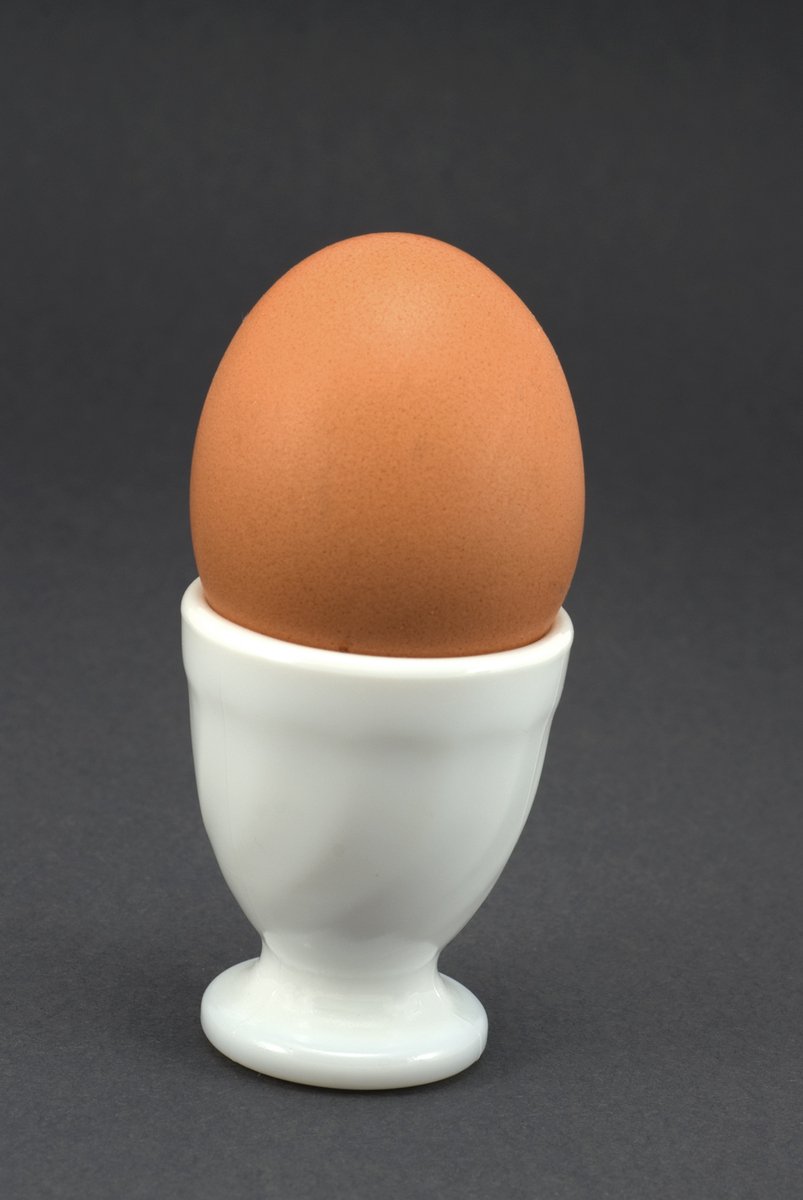 the egg is sitting inside of a cup
