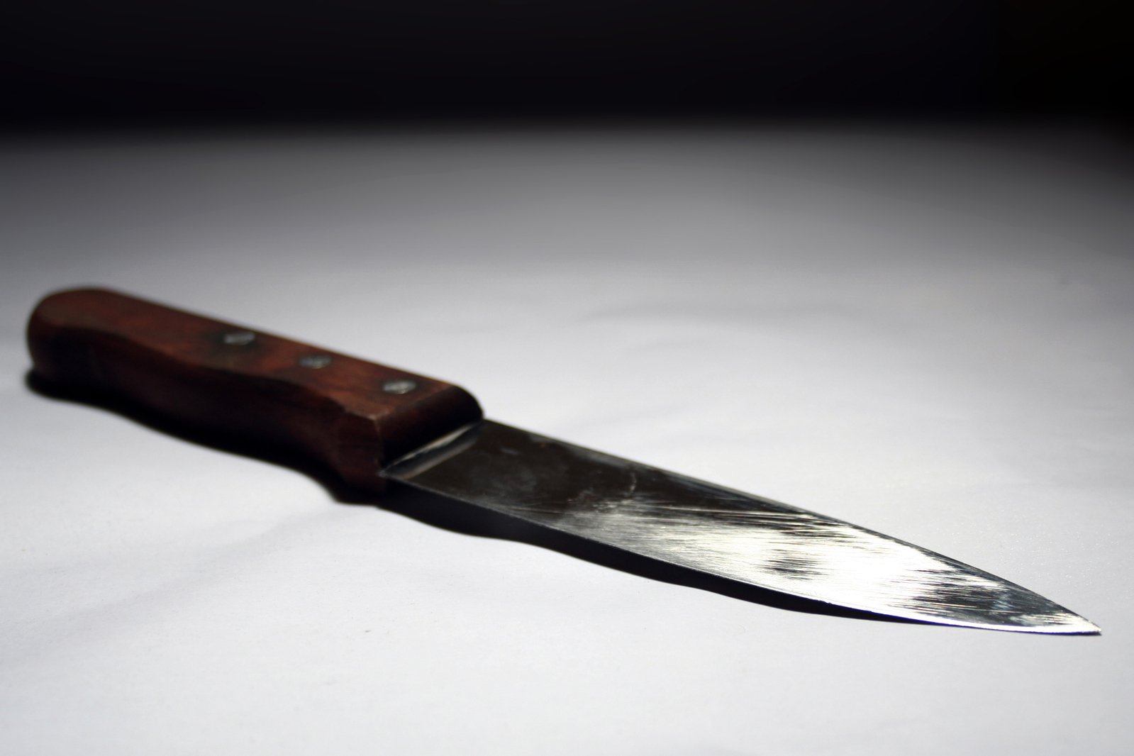 a knife with a wooden handle laying on a table