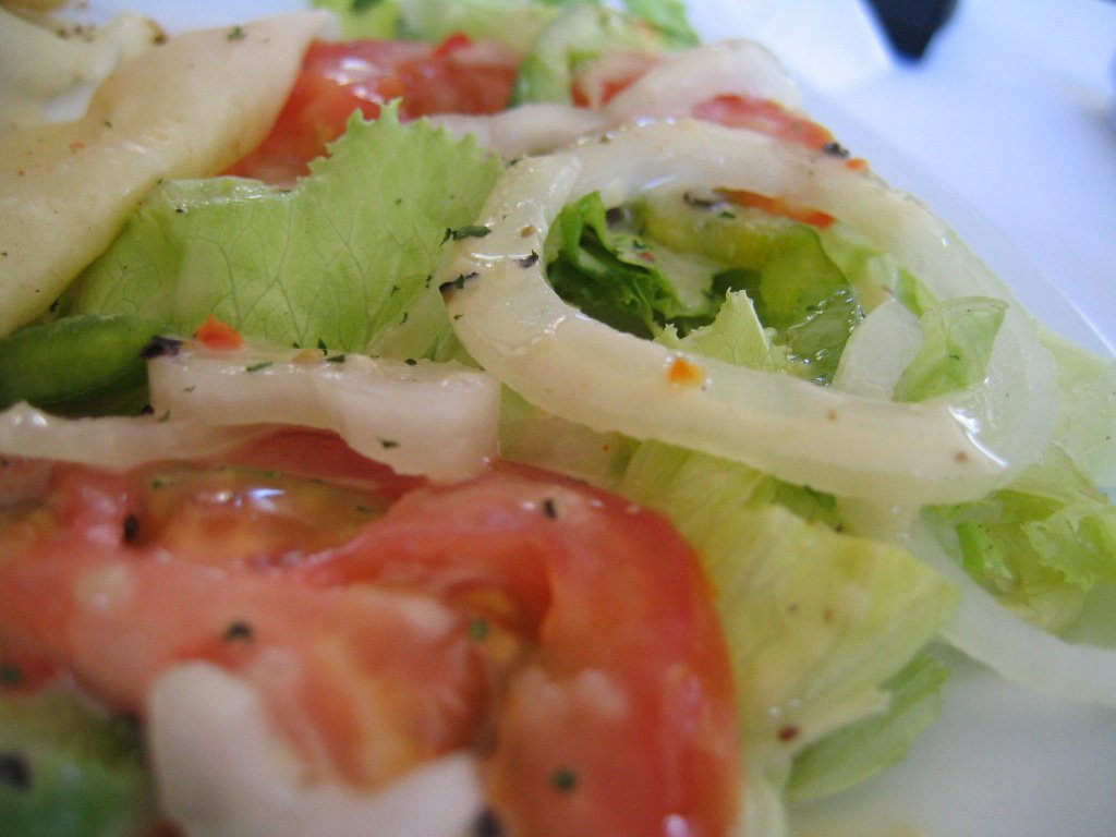 a salad with lettuce, tomato and onion