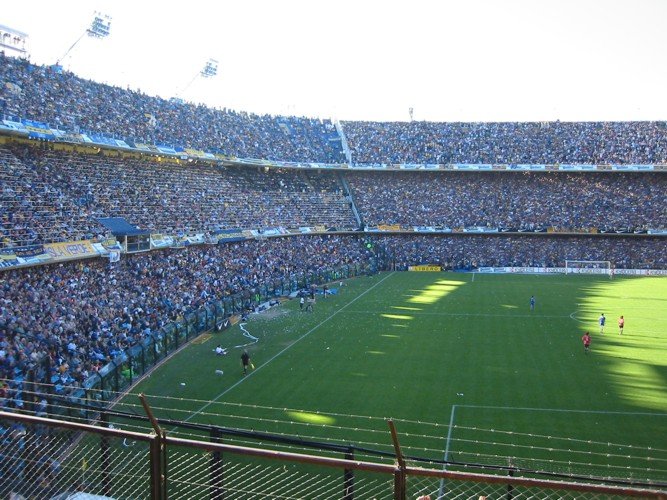 a large stadium full of people and people standing around