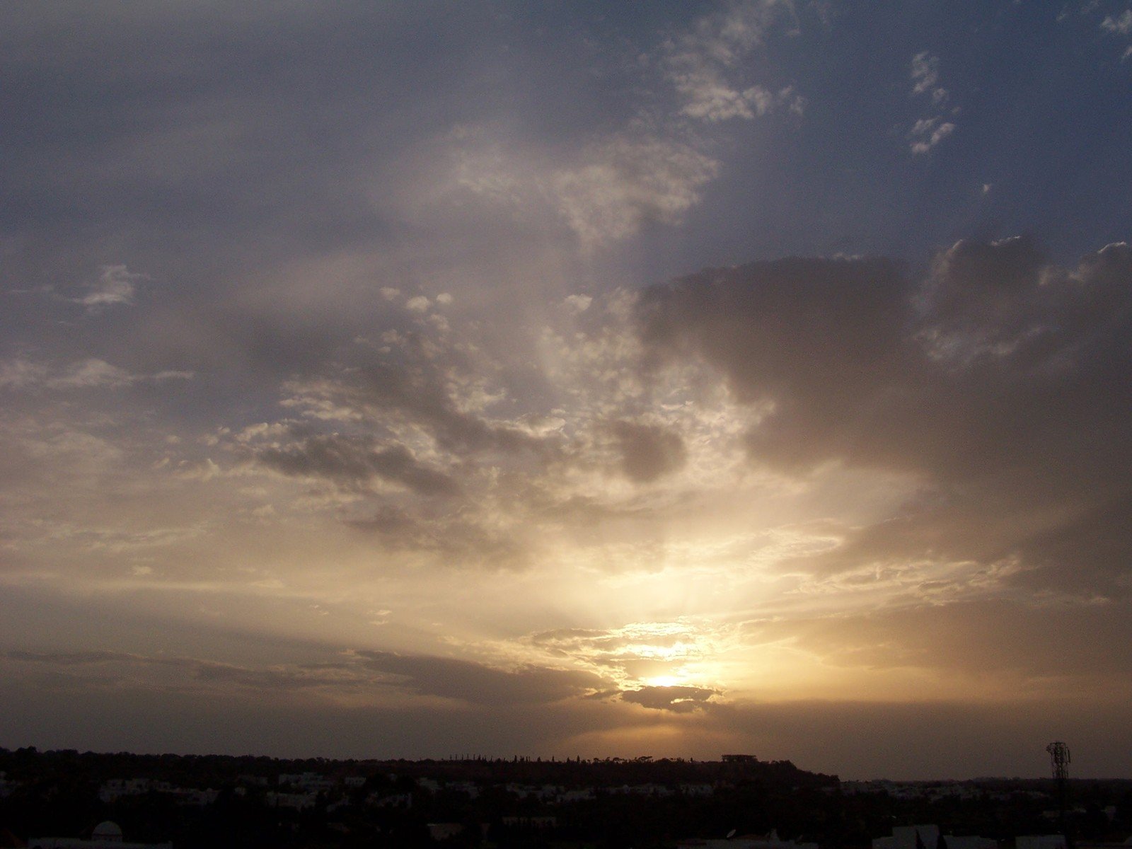 a sunset is seen behind a plane in the air