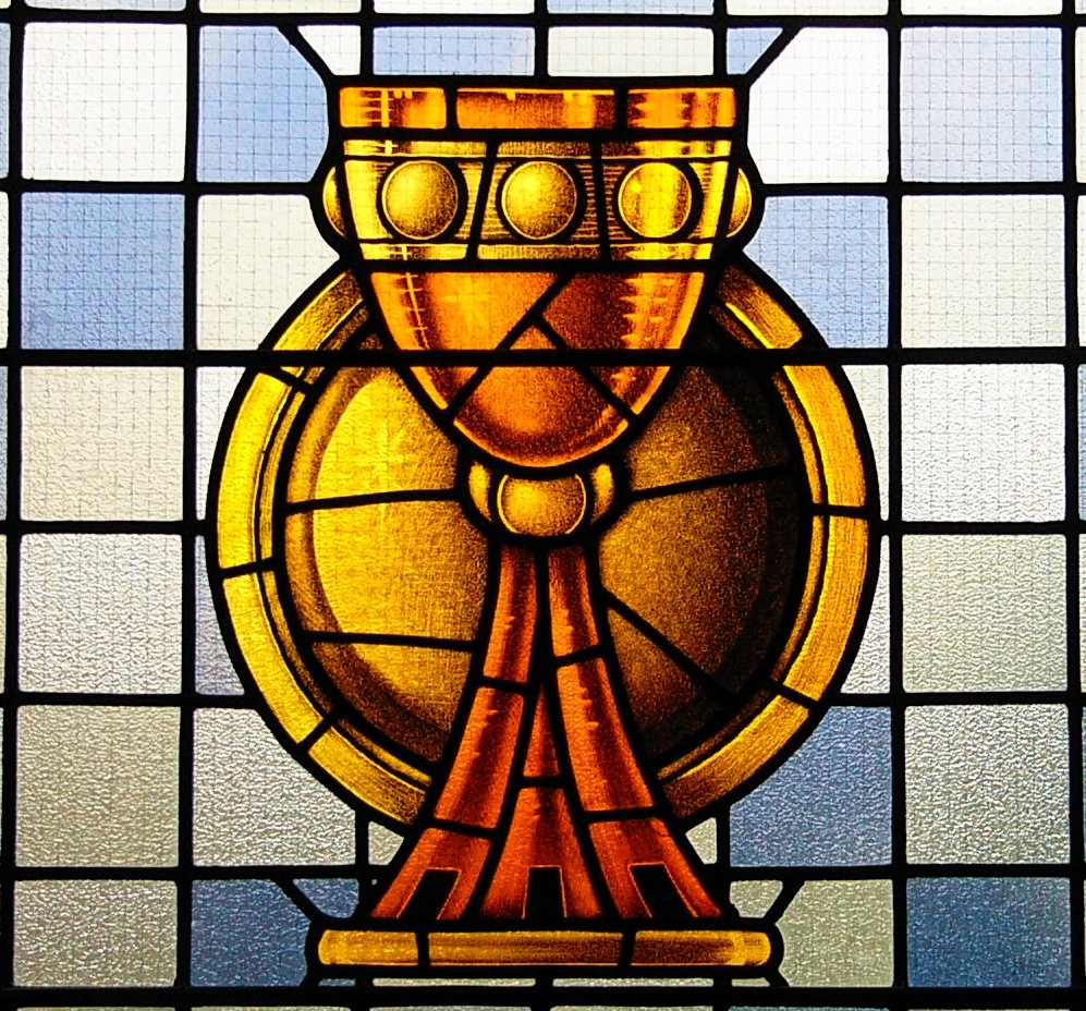 a stained glass window depicting an ancient golden cup and cross