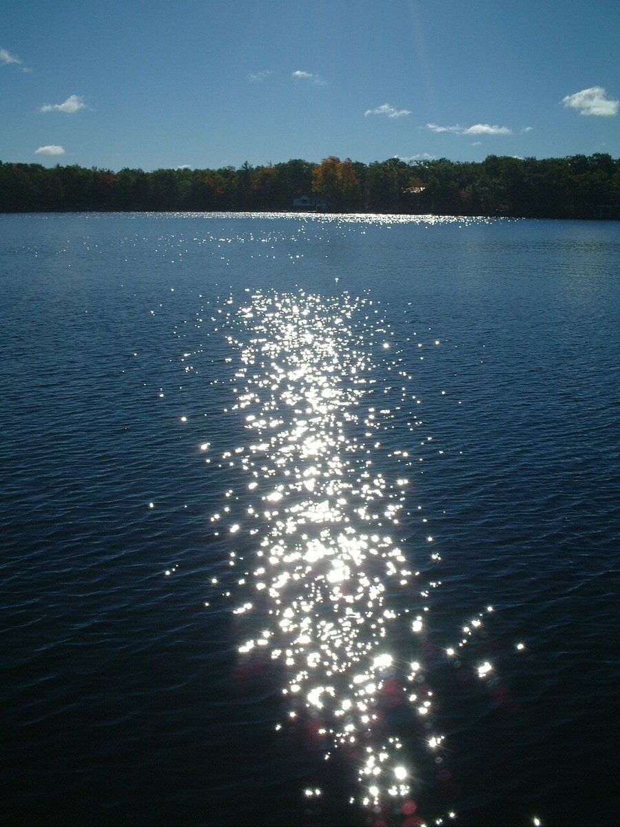 the sun is shining down on a lake