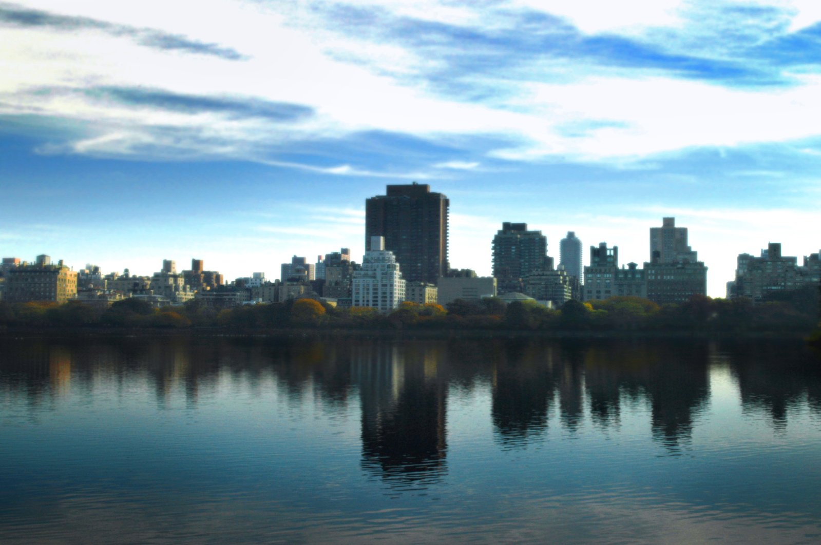 a city skyline with the lake reflecting buildings