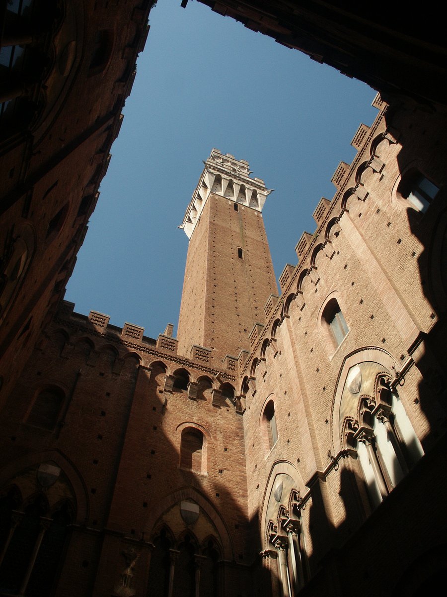 the view from below of a tall brick clock tower