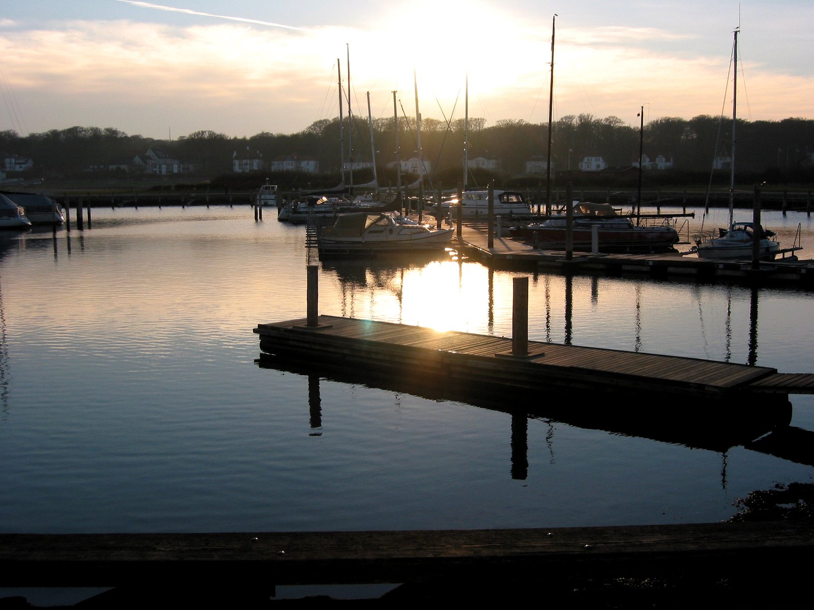 some boats are sitting at the dock in the sunset