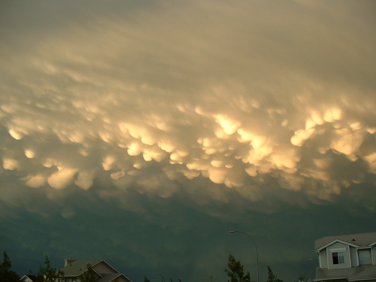 a large, cloud formation appears over residential buildings