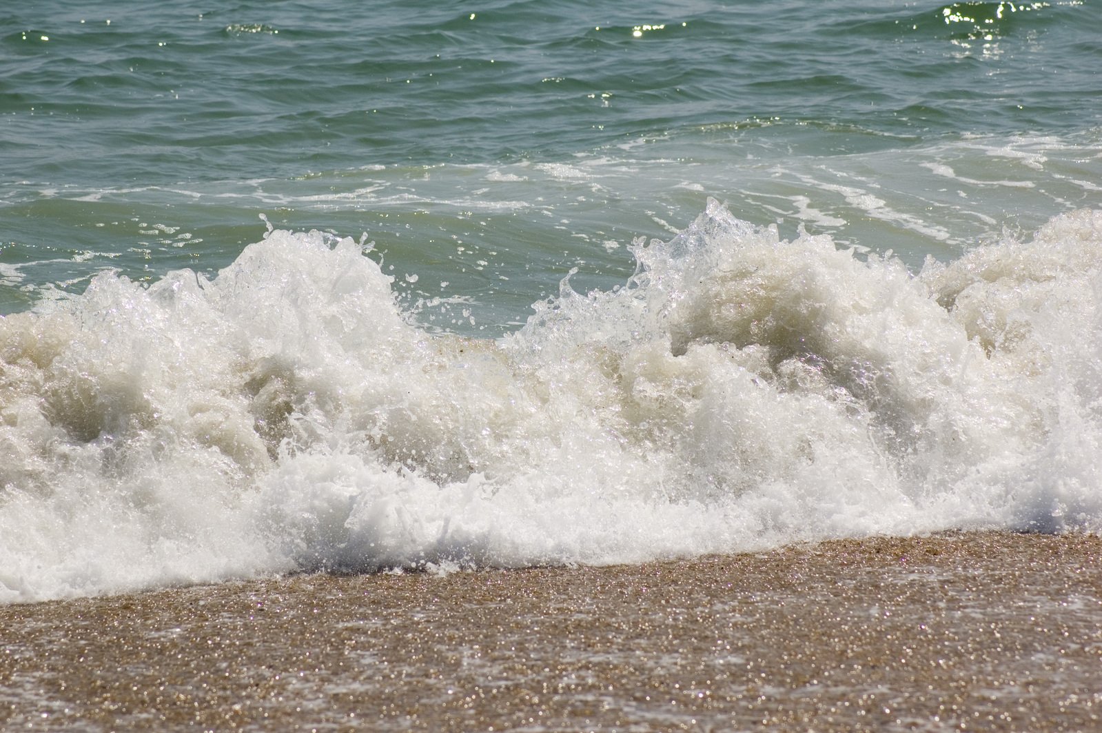 the ocean waves crash into shore near the beach