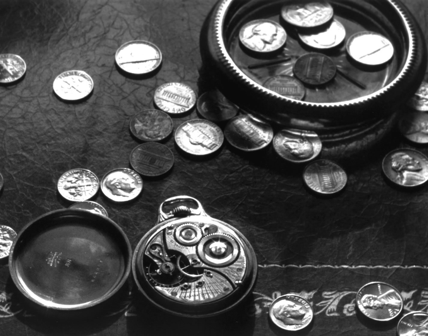 an antique pocket watch sits on top of a table with other coins