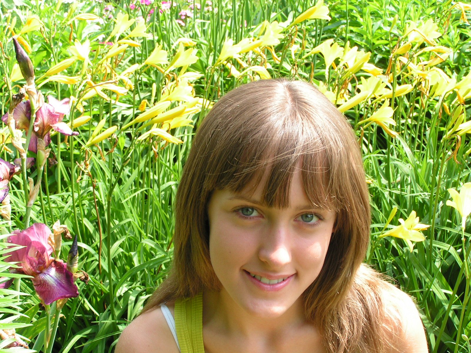 a woman standing in the grass looking straight ahead