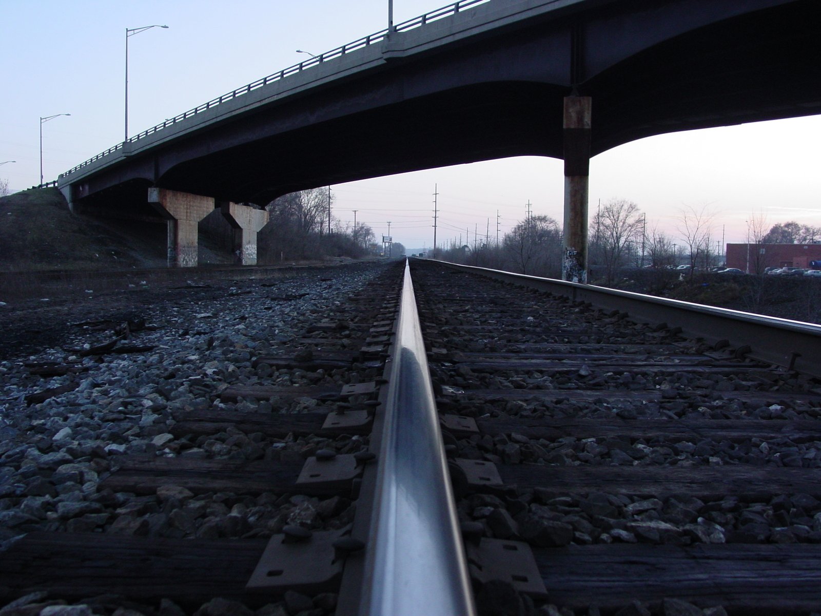 an overpass sits above the tracks as it crosses