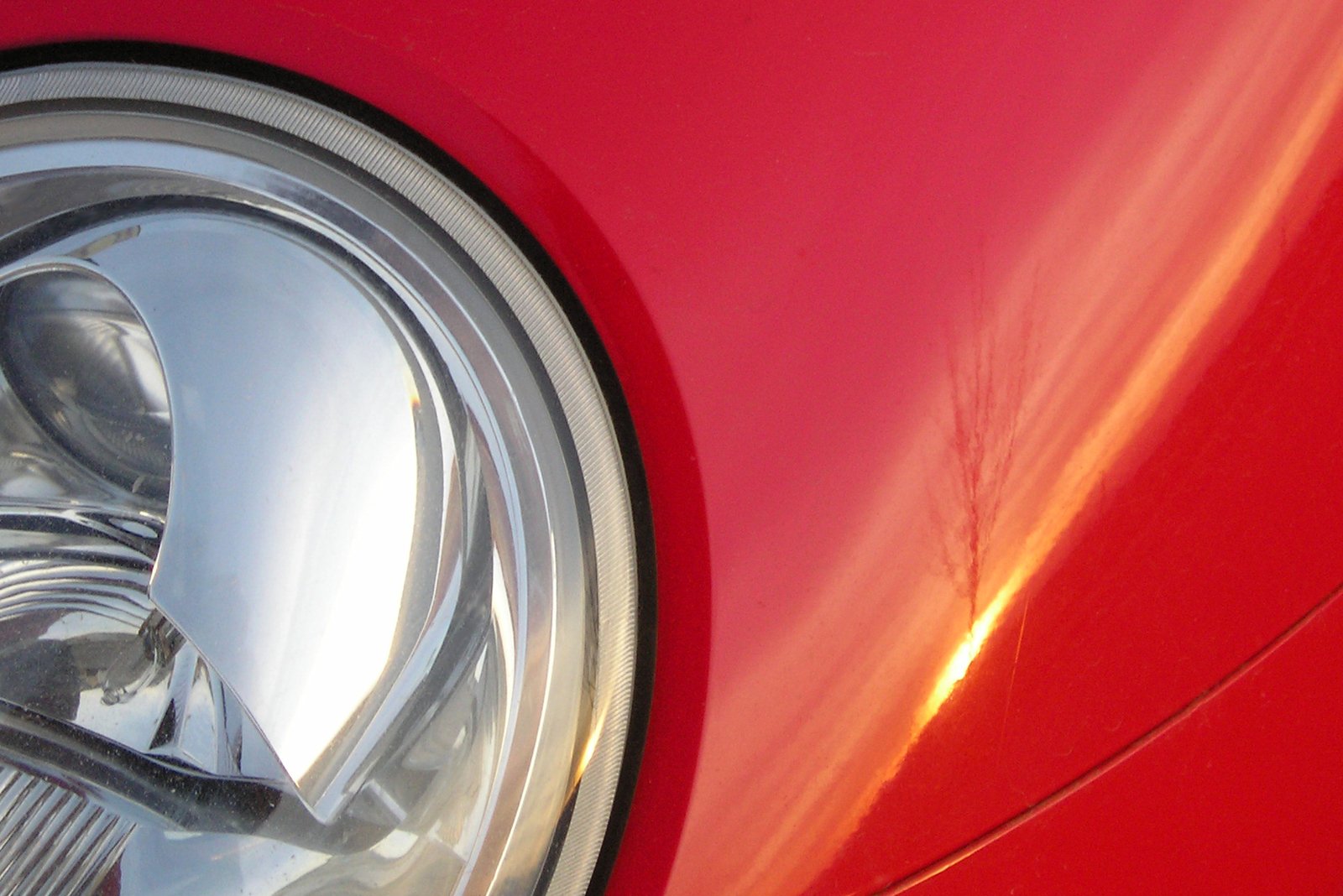 the hood and fender of a vintage red car