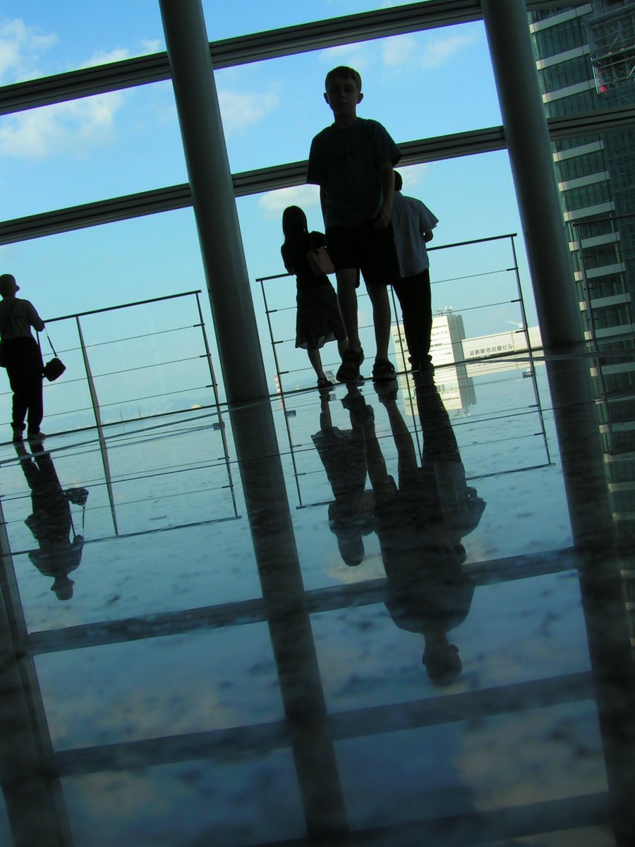 people walking through an airport and looking out the window